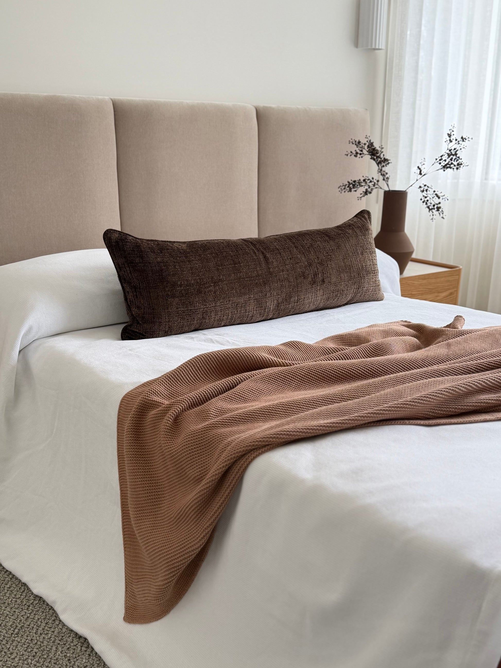 Conway Walnut chocolate-brown long lumbar cushion, 105x38cm, styled across a bed