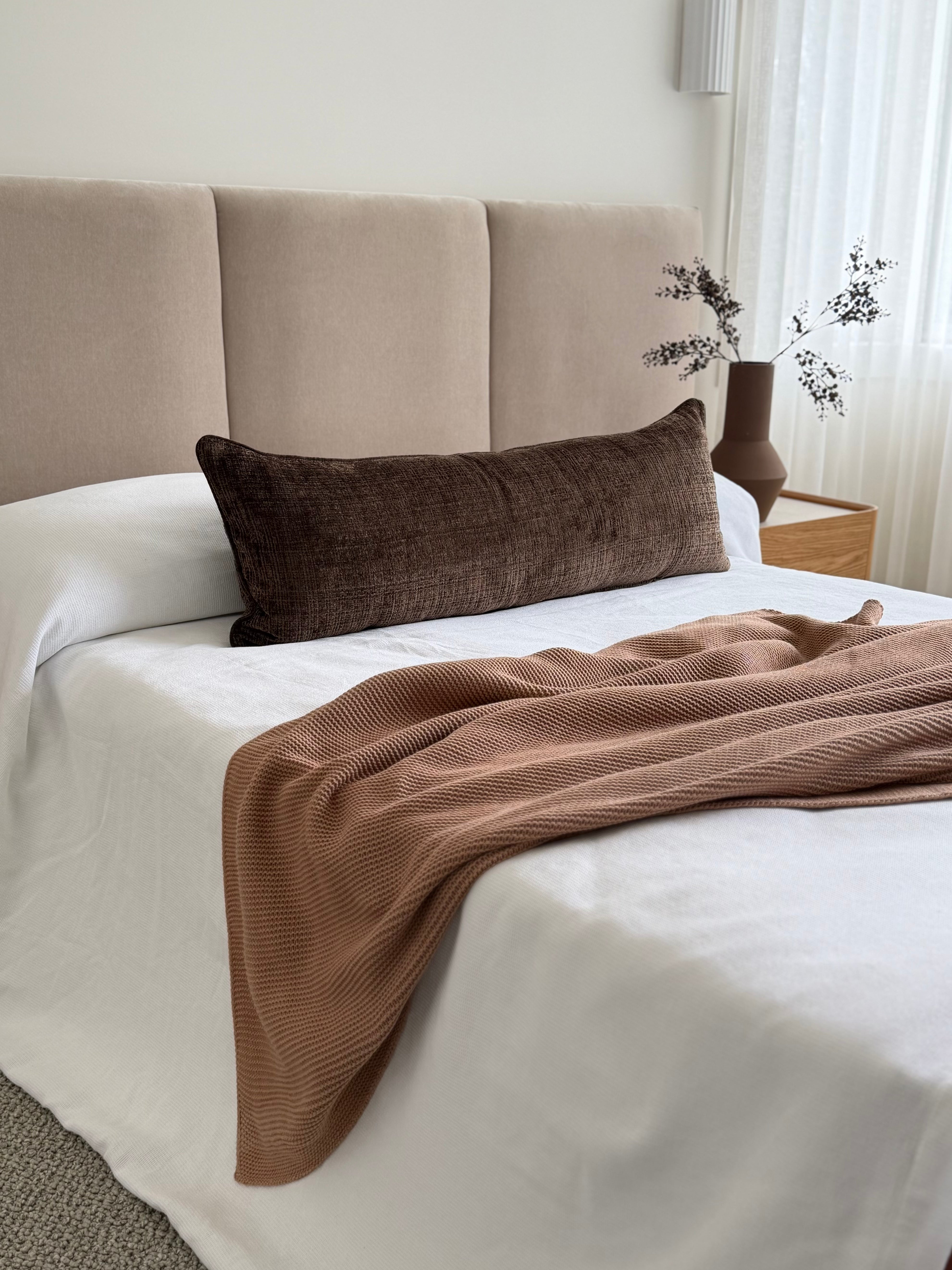 Conway Walnut chocolate-brown long lumbar cushion, 105x38cm, styled across a bed