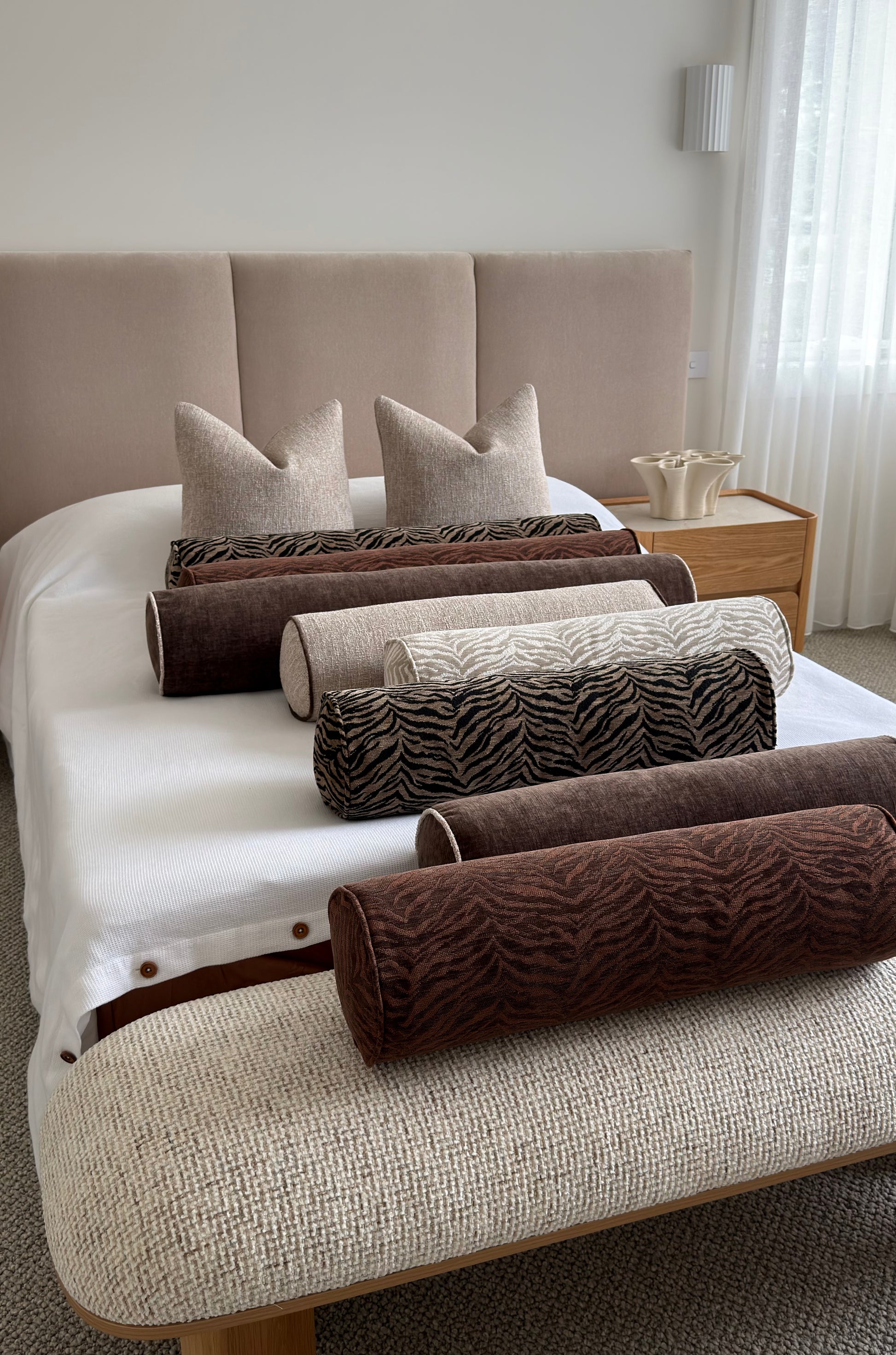 Essa Sandstone bolster cushion, stone woven fabric with espresso-brown piping