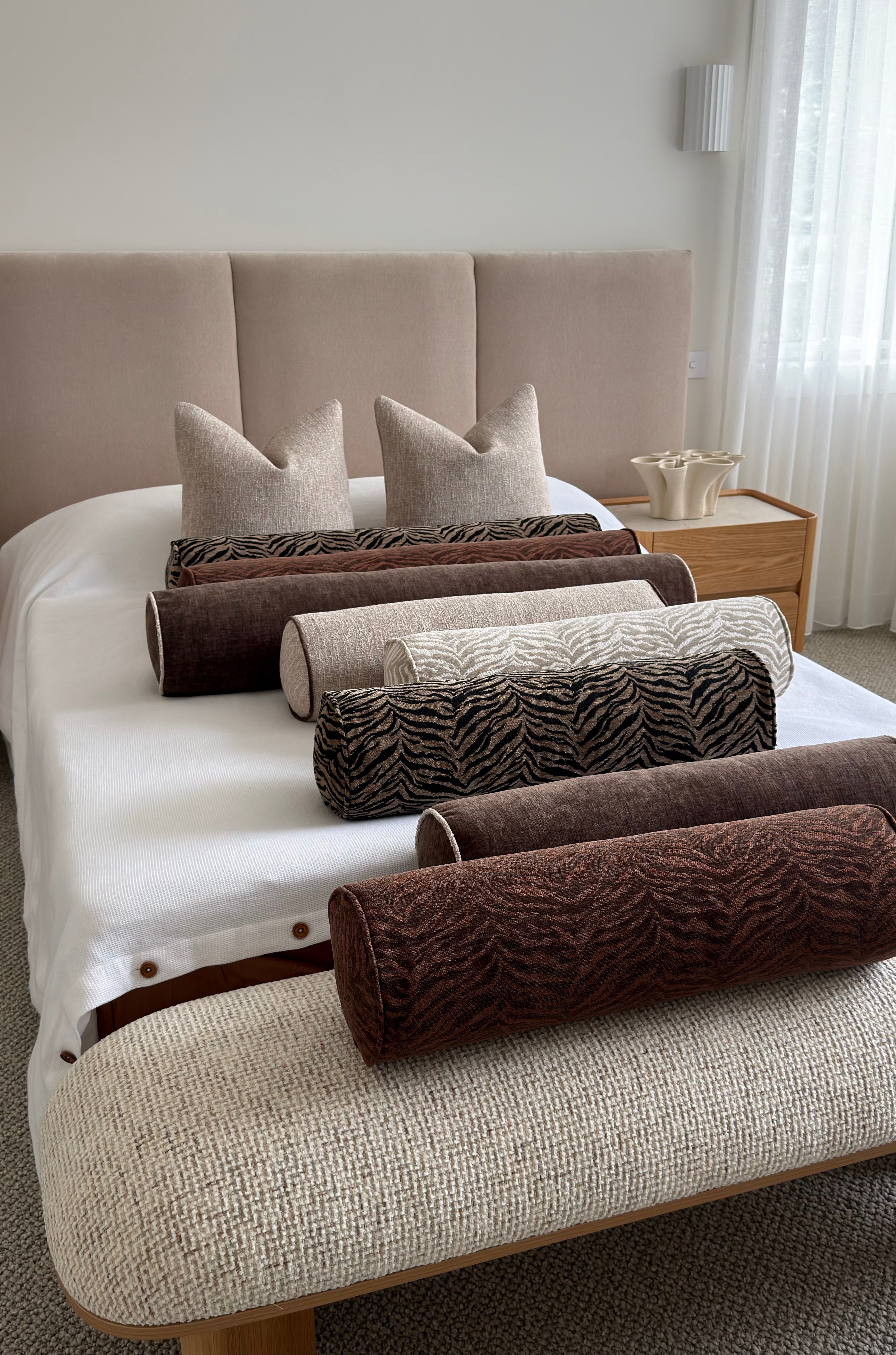Essa Sandstone bolster cushion, stone woven fabric with espresso-brown piping